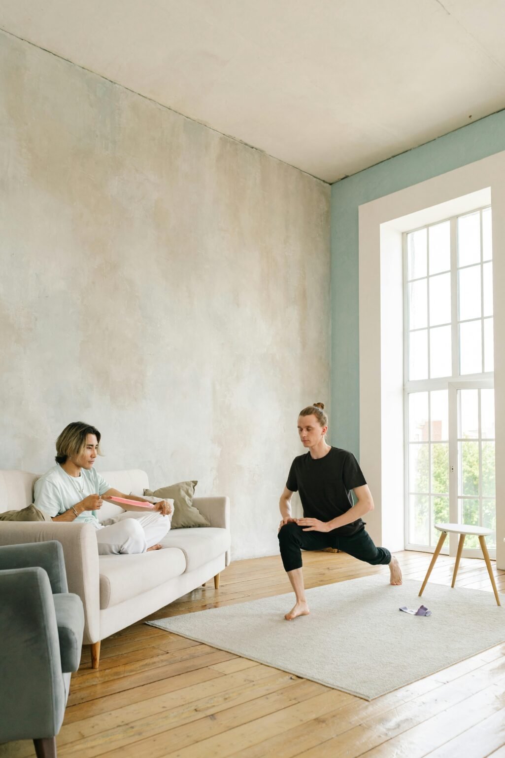 coaching sportif à la maison en intérieur, un homme sur le canapé et l'autre sur un tapis de yoga