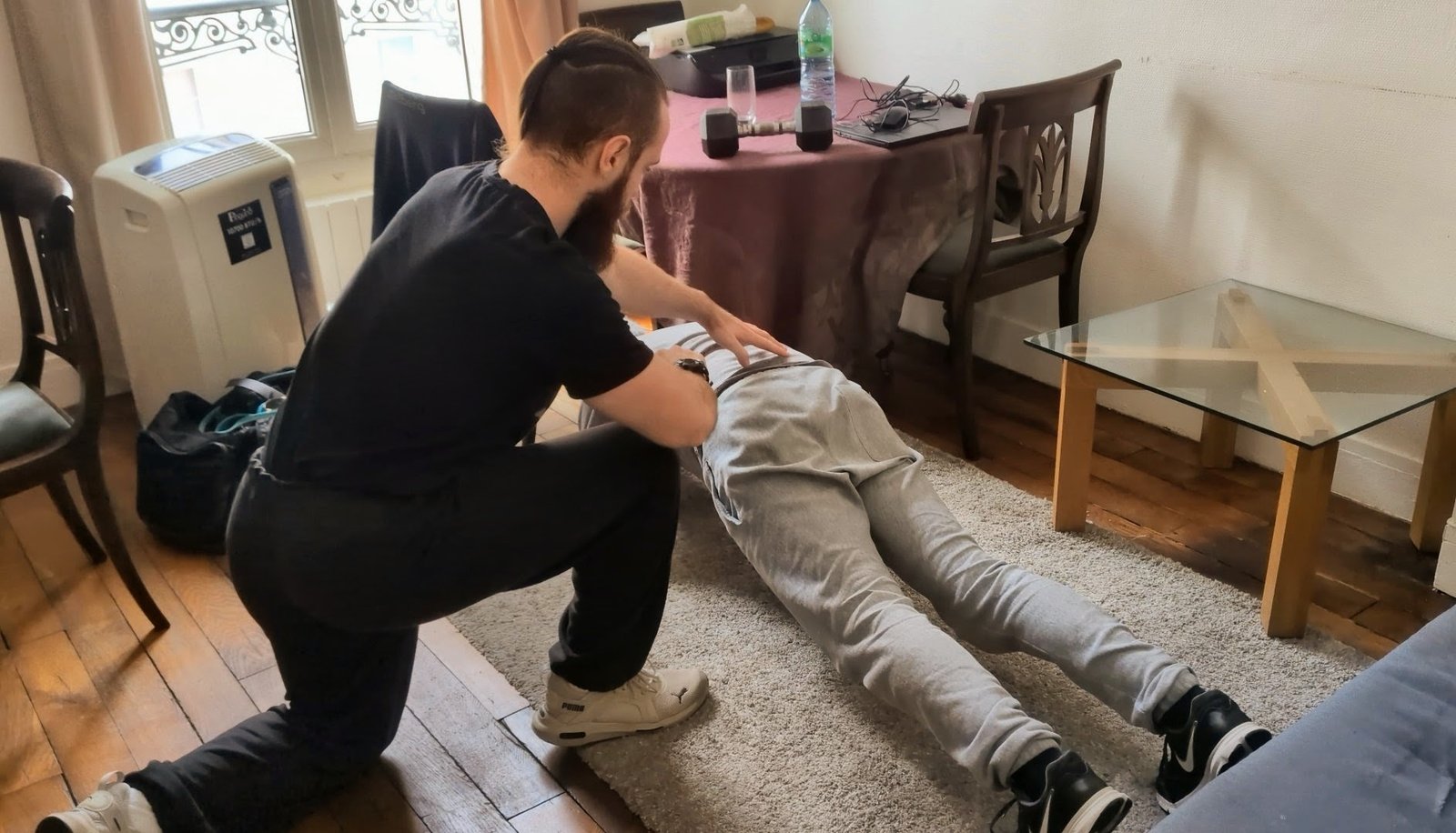 un coach sportif supervise un client qui fait des pompes