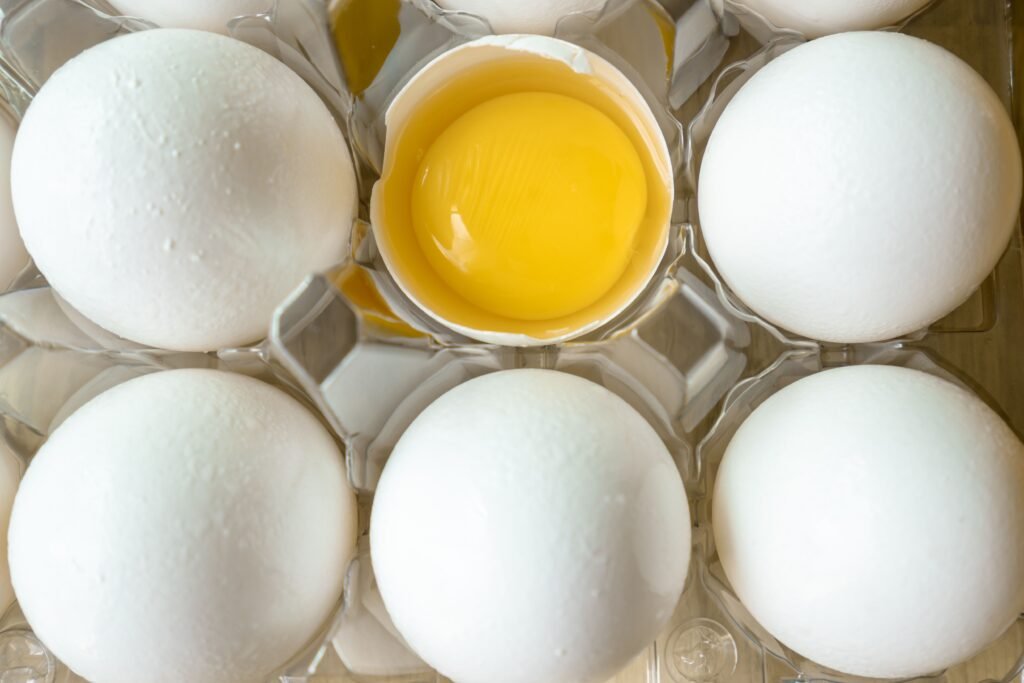 barquette d'oeufs dont un qui est ouvert, focus sur le jaune
