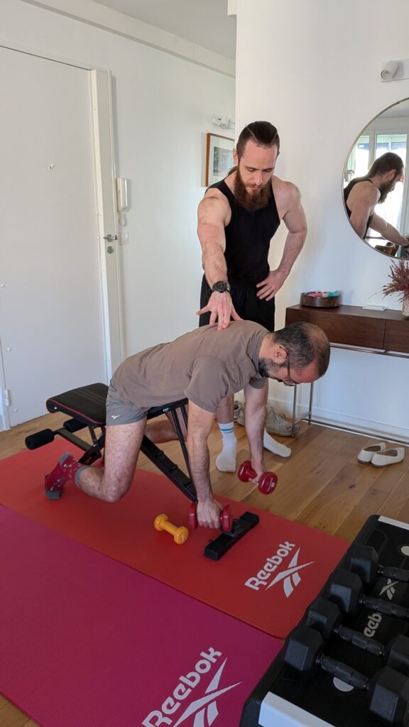 Homme s'entraînant sur banc de musculation sous supervision d'un coach