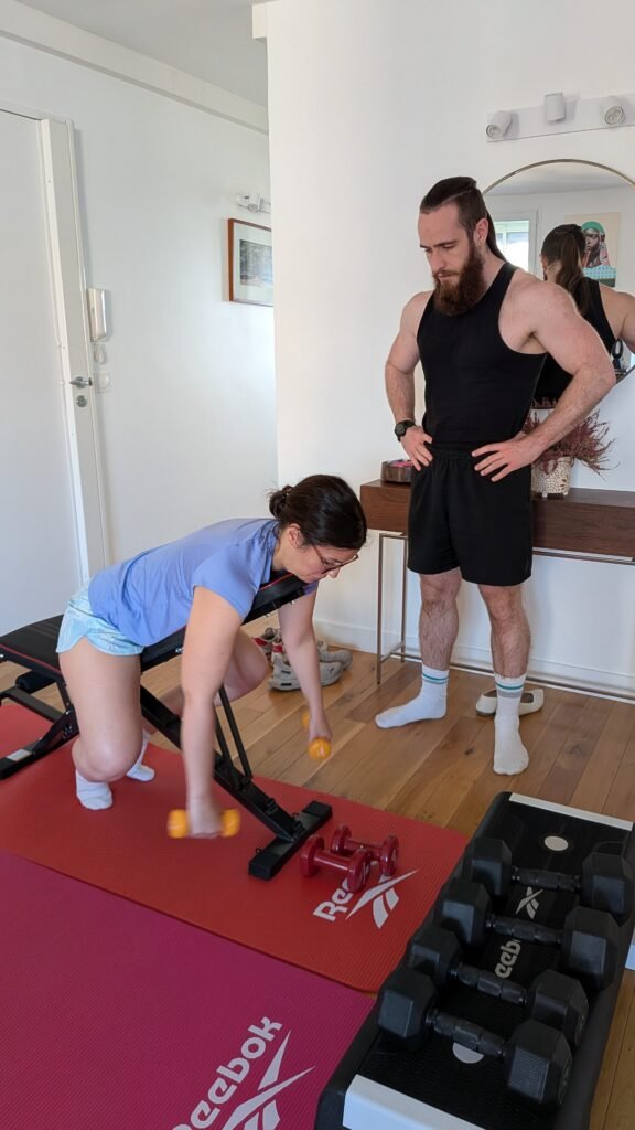 Femme faisant des exercices de poids sous la supervision d'un entraîneur